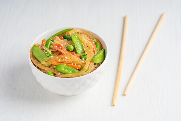 Japchae salato vegetariano piatto coreano di spaghetti di vetro saltati in padella piselli fagioli con bacchette