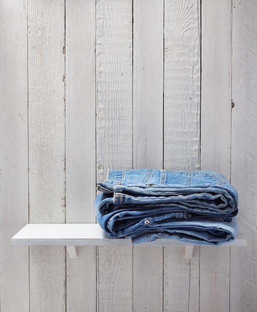 Jeans blu sullo scaffale di legno