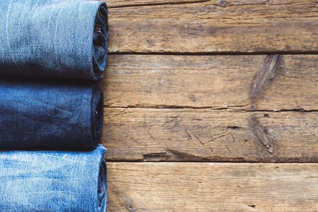 Jeans impilati su uno sfondo di legno