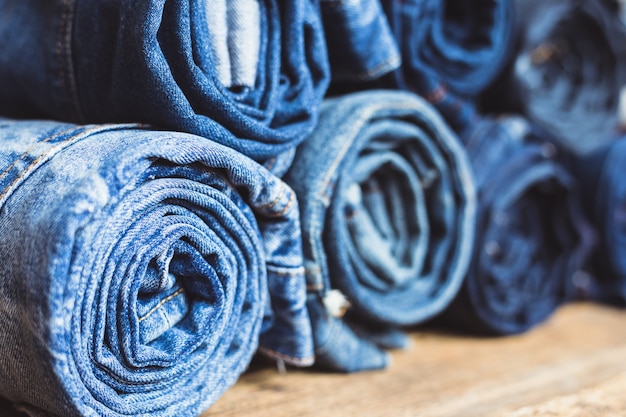 Jeans impilati su uno sfondo di legno