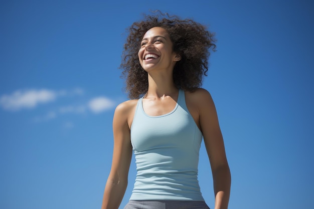 Joyful Young Woman in Casual Tank Top contro uno sfondo blu cielo