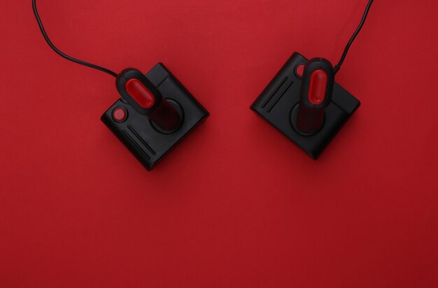 Joystick retrò su sfondo rosso. Gioco, competizione di videogiochi. Vista dall'alto