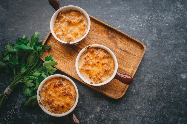 Julienne a porzioni, Funghi con panna e formaggio, Cibo da ristorante su fondo scuro