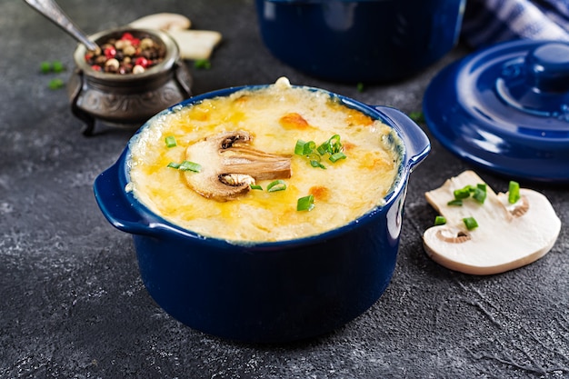 Julienne di funghi al forno con pollo e formaggio in vaso.