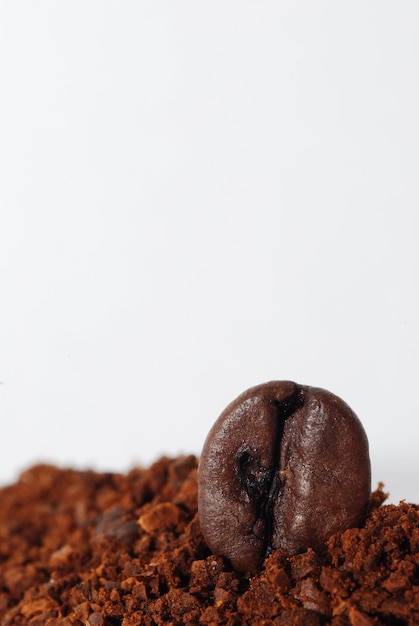 Kaffee gemahlen mit einer bohne auf weissen hintergrund hochformat