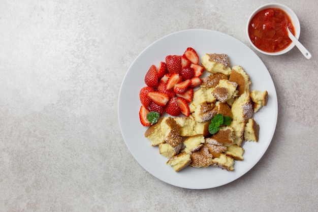 Kaiserschmarren o Kaiserschmarrn, dolce tradizionale austriaco o tedesco con frittelle di frutti di bosco freschi, marmellata di fragole o rote grutze e salsa di budino alla vaniglia