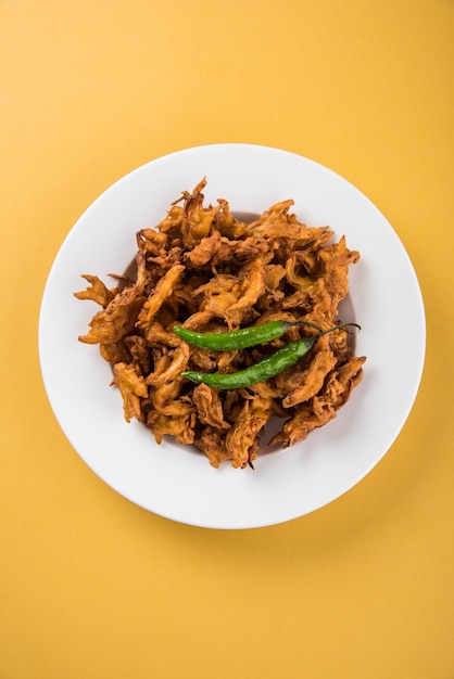 Kanda bhaji croccante o Bhajji o Pyaj Pakode o pakora di cipolla fritta, delizioso cibo di strada, snack indiano preferito in monsone servito con ketchup e tè caldo