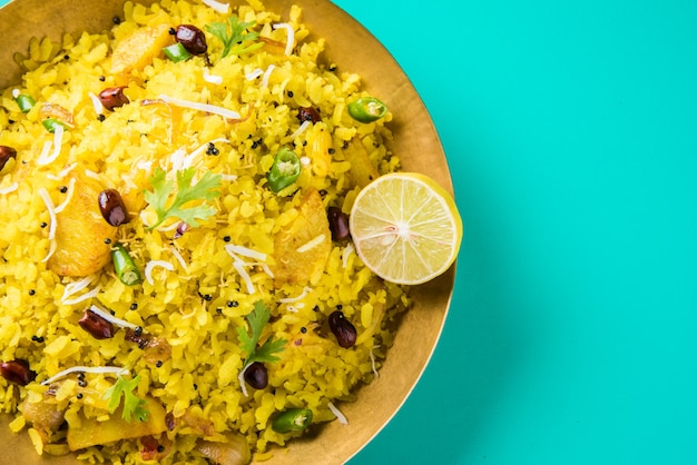 Kande Pohay O Aloo Poha è una famosa ricetta indiana per la colazione a base di riso appiattito, solitamente servito con tè caldo. Servito in una ciotola sopra. Messa a fuoco selettiva