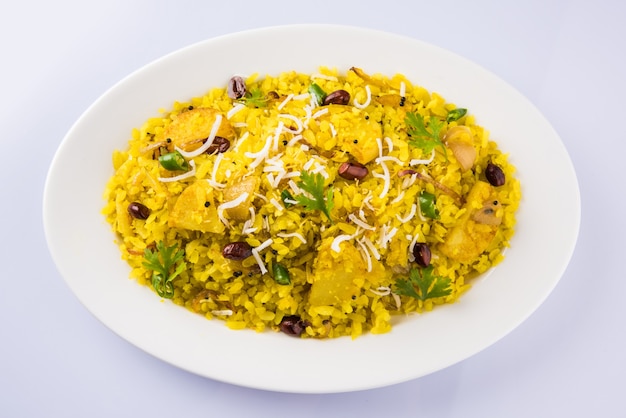 Kande Pohay O Aloo Poha è una famosa ricetta indiana per la colazione a base di riso appiattito, solitamente servito con tè caldo. Servito in una ciotola sopra. Messa a fuoco selettiva