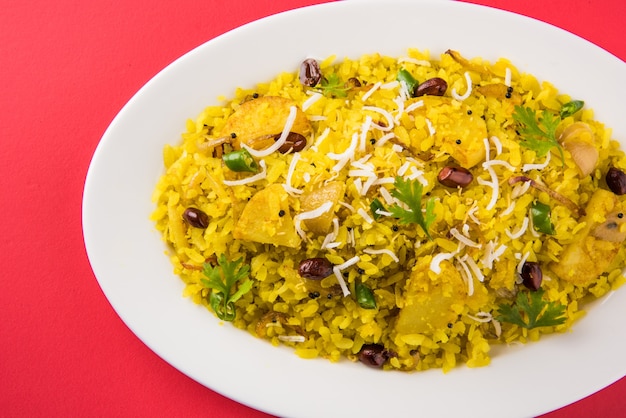 Kande Pohay O Aloo Poha è una famosa ricetta indiana per la colazione a base di riso appiattito, solitamente servito con tè caldo. Servito in una ciotola sopra. Messa a fuoco selettiva