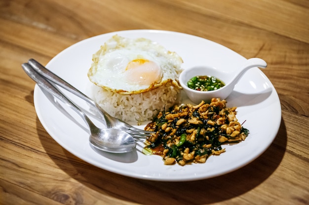 "Kao Pad Kra Prao" saltato in padella con carne di maiale tritata e uovo fritto, cibo tailandese alle spezie