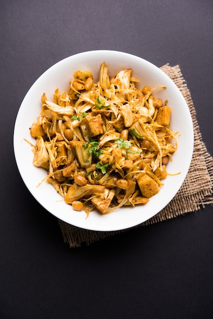 Kathal, Fanas ki Sukhi Sabzi o Bhaji noto come ricetta di verdure secche di Jackfruit piccante, servita in una ciotola bianca su sfondo lunatico. Messa a fuoco selettiva