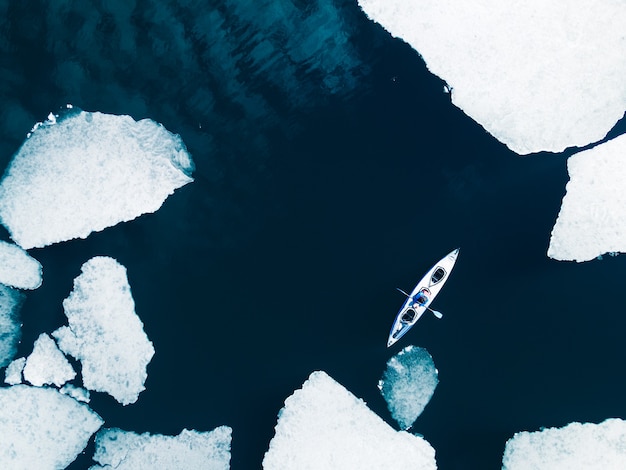 Kayak a vela tra banchi di ghiaccio sul lago Baikal in primavera. Vista aerea del drone. Lago Baikal, Siberia, Russia