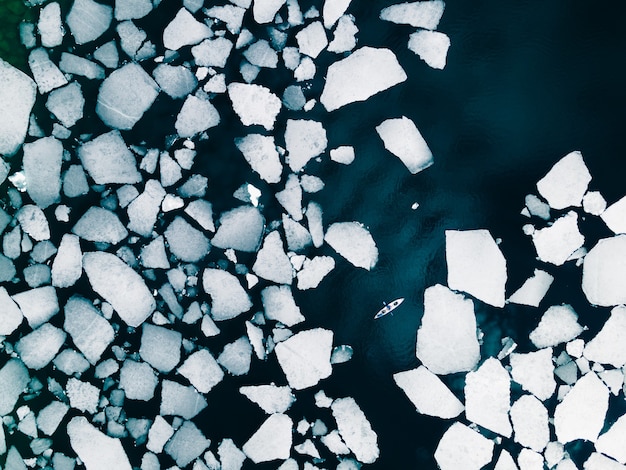 Kayak che naviga tra banchi di ghiaccio sul lago Baikal in primavera Vista aerea del drone Lago Baikal Russia