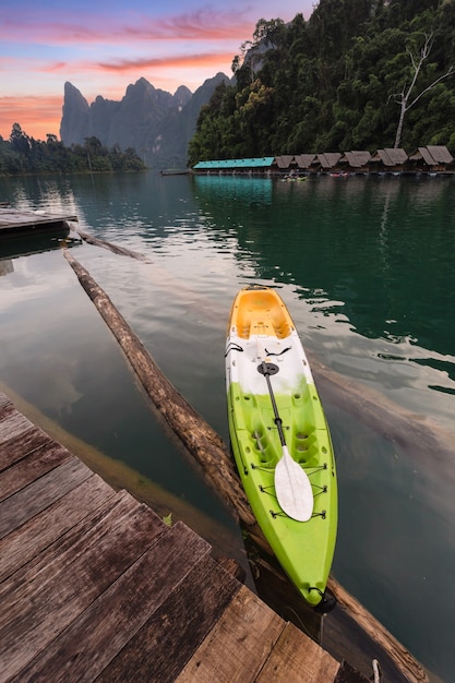 kayak in un molo in un lago con montagne e tramonto sullo sfondo del paesaggio