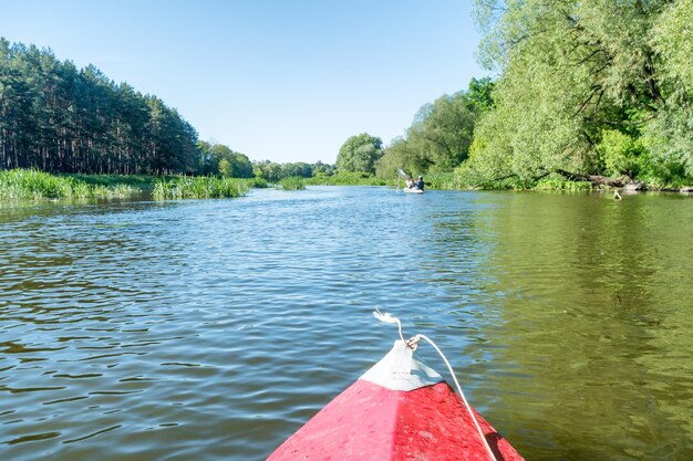 Kayak sul fiume. Paesaggio con acqua blu e alberi verdi