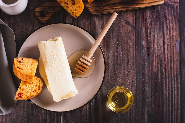 Kaymak lattiero-caseario turco cremoso miele e pane su un piatto da colazione vista dall'alto