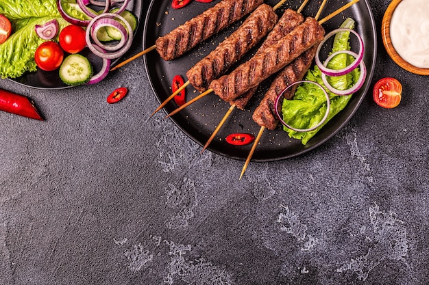 Kebab di carne tradizionale mediorientale, arabo o mediterraneo con verdure e pane pita. Vista dall'alto.