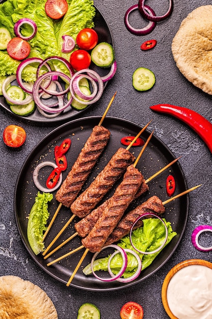 Kebab di carne tradizionale mediorientale, arabo o mediterraneo con verdure e pane pita. Vista dall'alto.