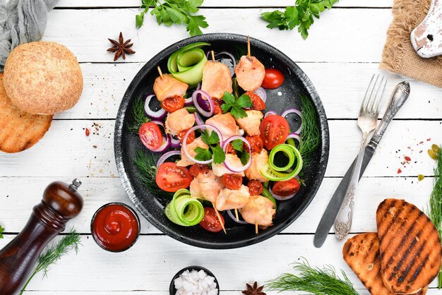 Kebab di pollo con verdure Kebab in un piatto nero Vista dall'alto Spazio di copia gratuito