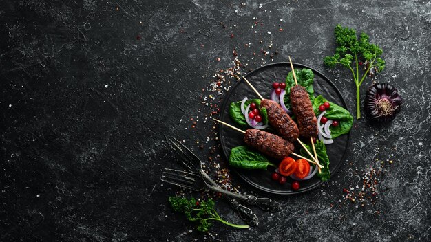 Kebab Tradizionale kebab di carne araba o mediterranea del Medio Oriente con verdure ed erbe aromatiche Vista dall'alto Spazio libero per il testo