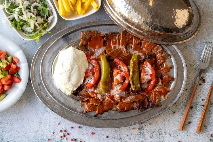 Kebab turco iskender su sfondo grigio Aromi tradizionali Kebab Doner fatto di manzo e agnello da vicino