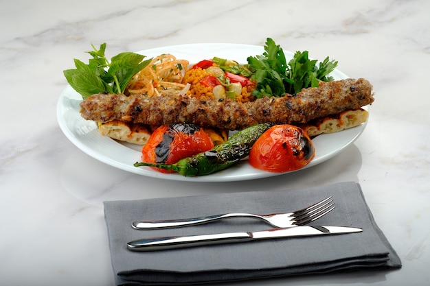 Kebab turco pronto per essere servito al tavolo adana urfa pollo shish kebab misto beyti