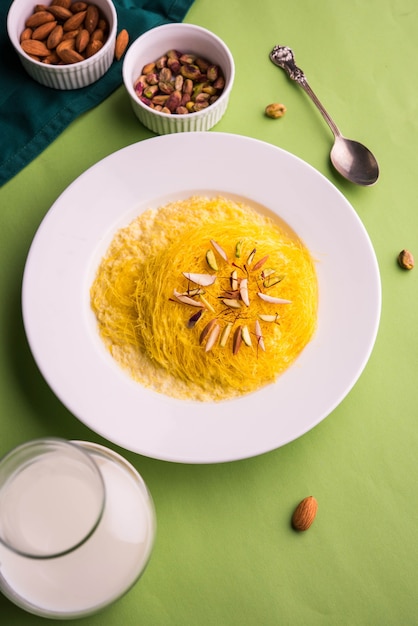 Kesar dolce indiano sutarfeni o sutar feni o firni o seviyan o laccha, farina di riso a scaglie sminuzzata arrostita nel burro chiarificato, mescolata con zucchero fuso per formare uno zucchero filato, con pistacchio e mandorle