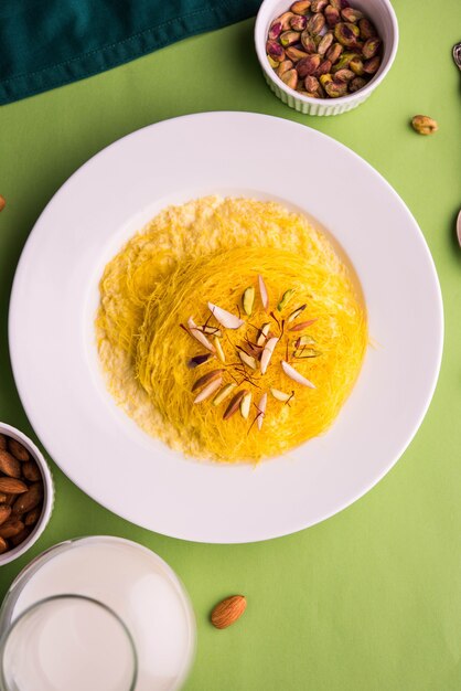 Kesar dolce indiano sutarfeni o sutar feni o firni o seviyan o laccha, farina di riso a scaglie sminuzzata arrostita nel burro chiarificato, mescolata con zucchero fuso per formare uno zucchero filato, con pistacchio e mandorle