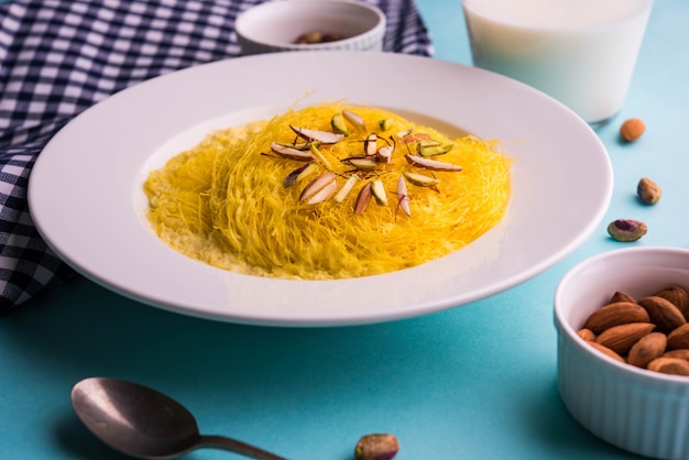 Kesar dolce indiano sutarfeni o sutar feni o firni o seviyan o laccha, farina di riso a scaglie sminuzzata arrostita nel burro chiarificato, mescolata con zucchero fuso per formare uno zucchero filato, con pistacchio e mandorle