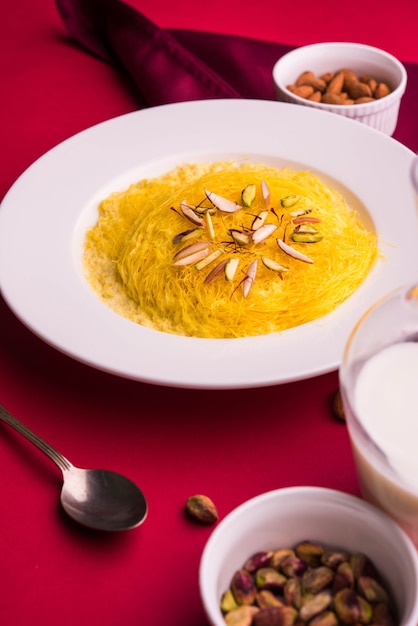 Kesar dolce indiano sutarfeni o sutar feni o firni o seviyan o laccha, farina di riso a scaglie sminuzzata arrostita nel burro chiarificato, mescolata con zucchero fuso per formare uno zucchero filato, con pistacchio e mandorle