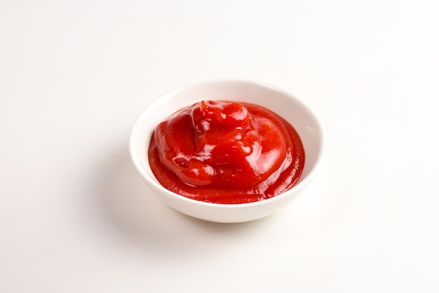 Ketchup in piatto bianco su sfondo bianco