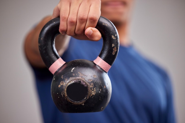 Kettlebell fitness e atleta uomo in palestra per un allenamento muscolare del braccio o allenamento sportivo Pesi sportivi e bodybuilder maschio sano che fa un esercizio di forza in una palestra o in uno studio benessere