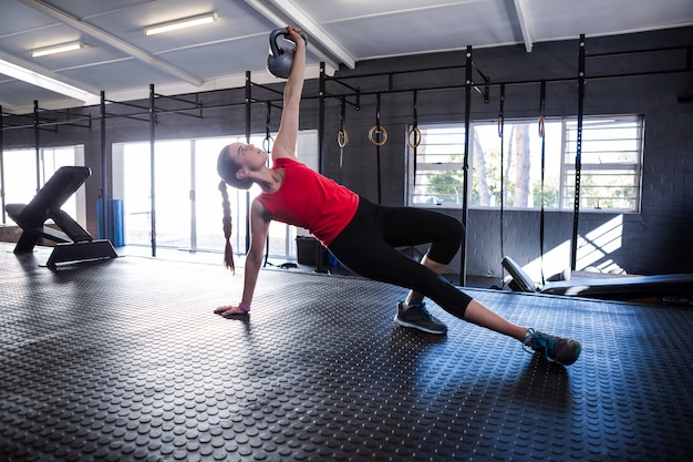 Kettlebell sportivo della tenuta dell'atleta femminile in palestra