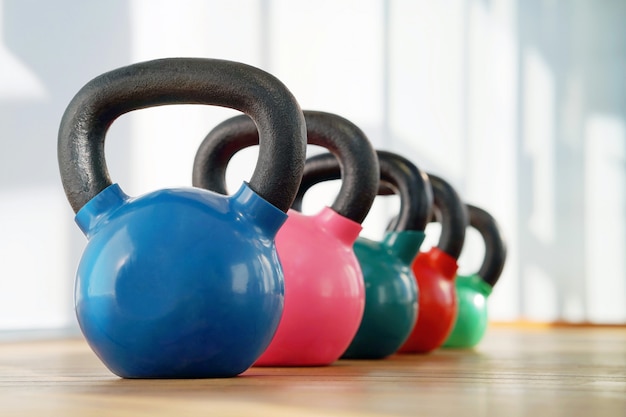 Kettlebells colorati in fila in una palestra