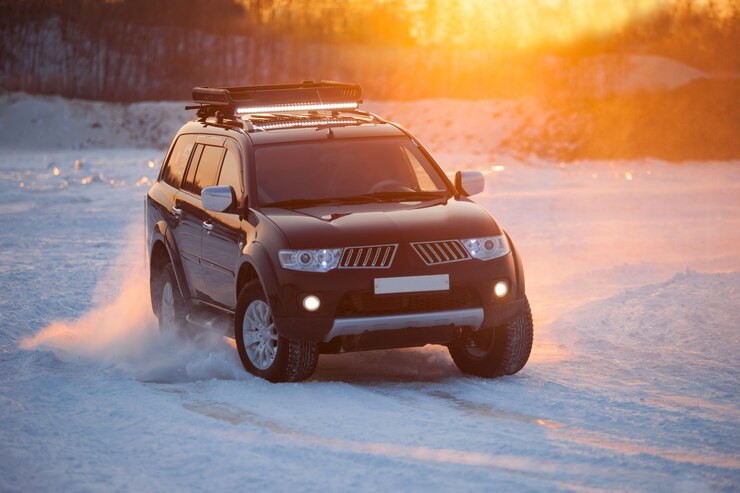 KHABAROVSK, RUSSIA - 28 GENNAIO 2017: Mitsubishi Pajero Sport che si muove sul ghiaccio di un fiume frosn al tramonto