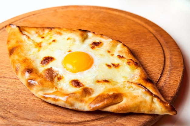 Khachapuri o hachapuri di focaccia tradizionale di Ajarian con uova di formaggio e burro su un piatto