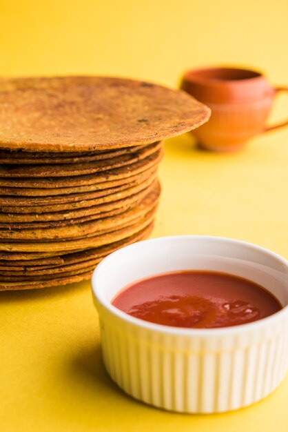 Khakhra o Khakra è un cracker sottile è un popolare cibo per la colazione Jain, Gujarati e Rajasthani. Servito con tè caldo e ketchup. Su sfondo colorato o in legno