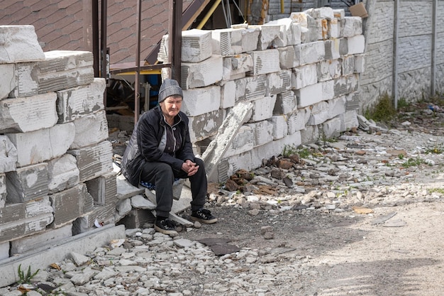 KHARKIV UCRAINA 04 maggio 2022 Una donna anziana è seduta sulla soglia della sua casa in rovina