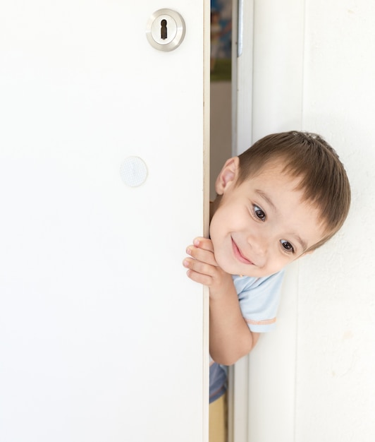 Kid che sbircia dalla porta della stanza aperta