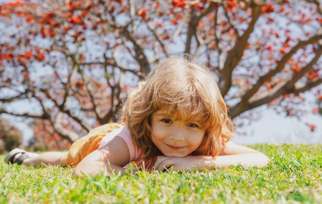 Kid posa sull'erba Autunno bambini cadono le foglie