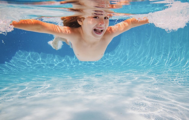 Kid ragazzo nuotare sott'acqua in piscina bambino nuoto e immersioni subacquee in piscina d'acqua bambini sott'acqua a