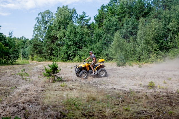 Kiev - settembre 2019 Uomo che guida un quad fuoristrada ATV giallo su una foresta sabbiosa. Moto estremo, avventura, attrazione turistica.