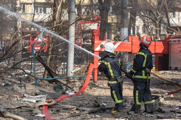 KIEV UCRAINA 15 marzo 2022 Guerra in Ucraina Vigili del fuoco che combattono un incendio in un edificio residenziale che è stato colpito da un proiettile russo