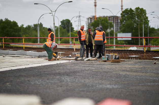 Kiev Ucraina 15 settembre 2020 I lavoratori stradali in giubbotti arancioni riparano la superficie stradale