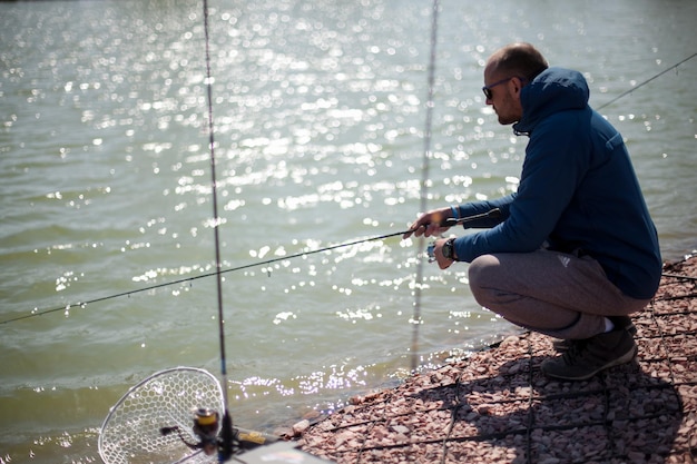 Kiev, Ucraina, 16 aprile 2018. Il pescatore caucasico cattura il pesce con una canna da spinning sul lago.