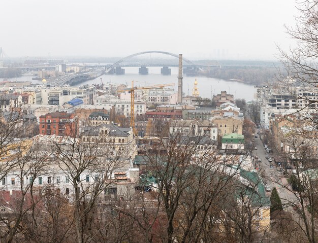 Kiev, Ucraina - 16 novembre 2019: Paesaggio urbano del distretto di Podol nella città di Kiev al giorno nebbioso. Ponte Podolsky