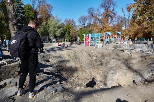 Kiev Ucraina 16 ottobre 2022 persone vicino all'imbuto dall'esplosione di un razzo russo in un parco giochi per bambini nel centro della capitale