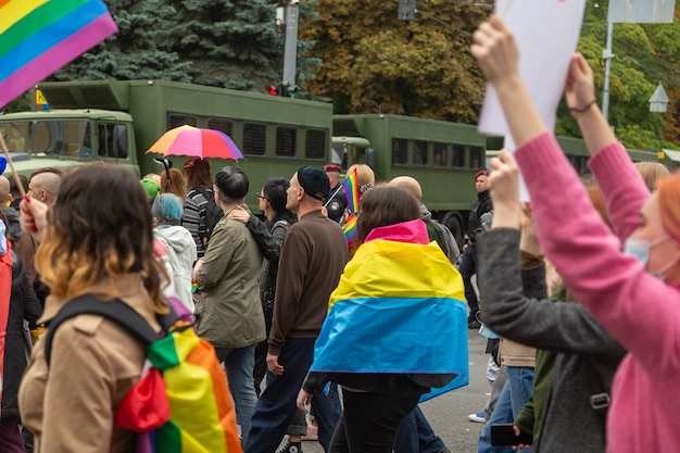 Kiev, Ucraina - 19.09.2021: Comunità LGBTQ al Pride Parade. Partecipanti alla marcia con simboli arcobaleno sullo sfondo di speciali auto della polizia.