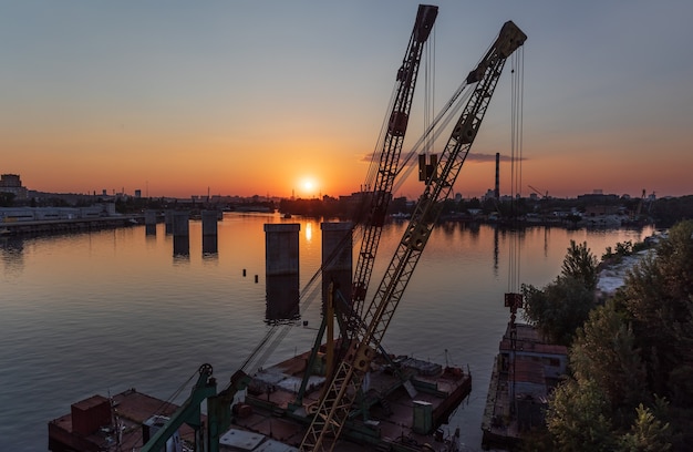 KIEV, UCRAINA - 30 maggio 2018: Distretto industriale di Kiev nel distretto di Podil. Dnepr e il porto fluviale. Vista dal ponte Rybalsky strallato la sera durante il tramonto